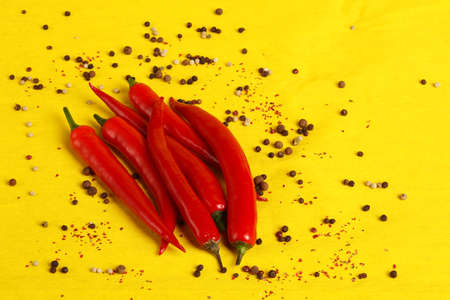 Red chili peppers on a yellow background, a close-up place for the inscription. High quality photoの写真素材