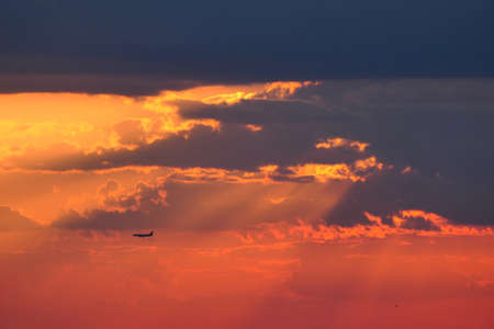 Beautiful sunset. Airplane in the sky against the background of the dark sky. High quality photoの写真素材