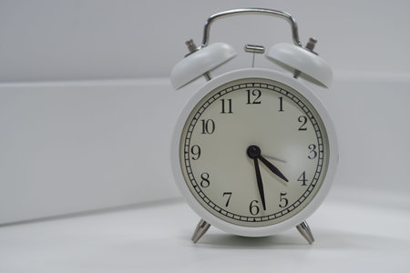 Alarm clock white round, close-up isolated on a white table. High quality photo
