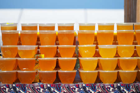 Natural honey in jars. A beautiful showcase for the sale of natural honey. High quality photoの写真素材