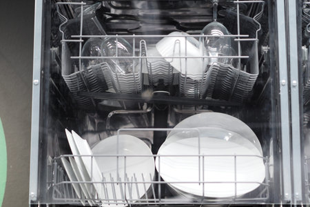 The dishwasher is full of clean dishes, kitchen appliances. High quality photo