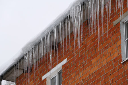 Large icicles on the roof of the house. high quality photo