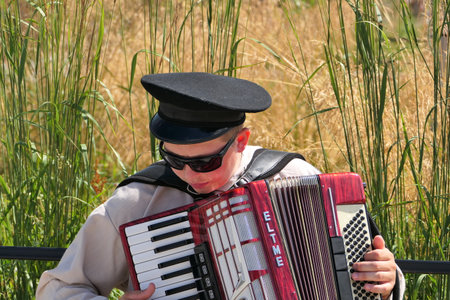 Nizhny Novgorod, Russia, st. Sovnarkomovskaya 13, 07.30.2022. The musician plays the accordion on the street in summer. High quality photoのeditorial素材