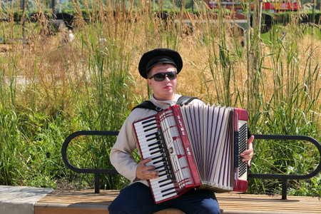 Nizhny Novgorod, Russia, st. Sovnarkomovskaya 13, 07.30.2022. The musician plays the accordion on the street in summer. High quality photoのeditorial素材