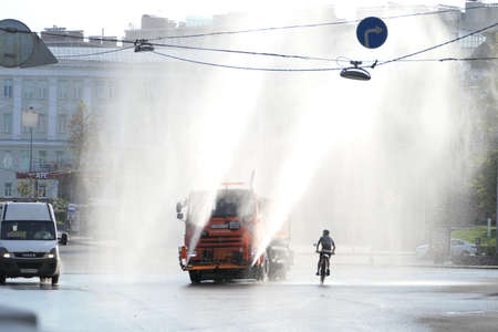 Nizhny Novgorod, Russia, Minin Square, Zelensky Suzd, 08.14.2022. The machine waters the streets of the city in the summer in hot weather, cleaning the city in the early morning. watering machine in the city. high quality photoの写真素材
