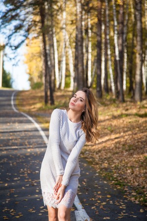 beautiful girl walking in the autumn forest with yellow leavesの写真素材