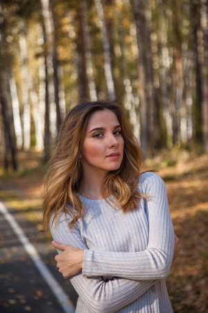 portrait of a beautiful girl in the autumn forest with yellow birch leaves.の写真素材
