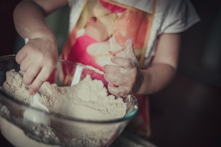 little girl baking cookies. Hands in flourの写真素材