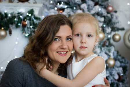 mother and daughter sitting at the Christmas treeの写真素材
