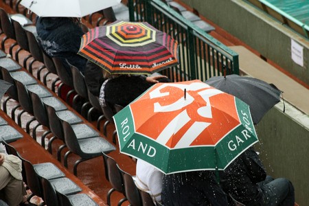 PARIS - MAY 27: Spectators wait under umbrellas as matches are delayed due to rain at French Open, Roland Garros on May 27, 2010 in Paris, France.のeditorial素材