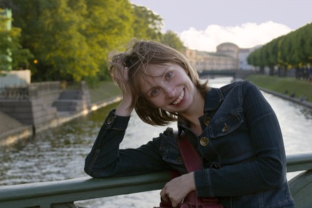Smiling girl in sunset lights standing on the bridge in St.Petersburg, Russiaの写真素材