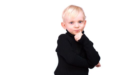 Studio piortrait of beautiful serious three years old blond little boy wearing black sweater isolated on whiteの写真素材