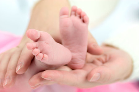 Mother's hands holding Baby's tiny feet