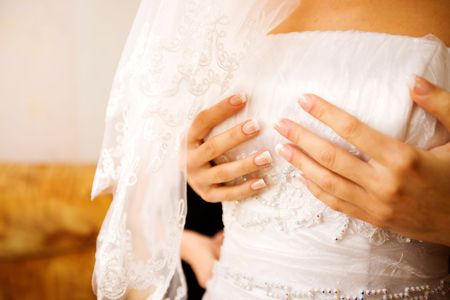 Bride dressing up holding top の写真素材