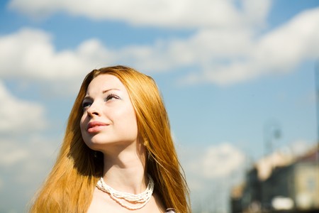 Young woman looking up to the sun portraitの写真素材
