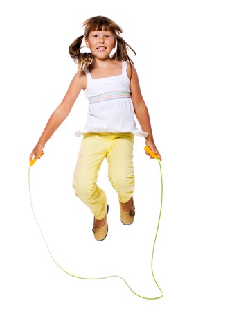 Seven years Girl jumping with skipping rope isolated on whiteの写真素材