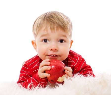 Two years Boy eating red apple isolated on whiteの写真素材