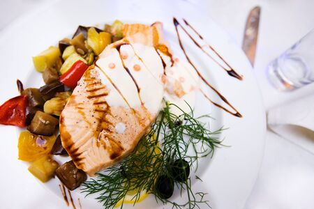 Salmon ish dish decorated on white plate in restaurantの写真素材