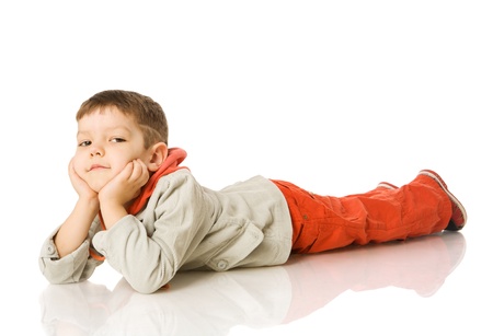 Four years boy lying on floor isolated on whiteの写真素材