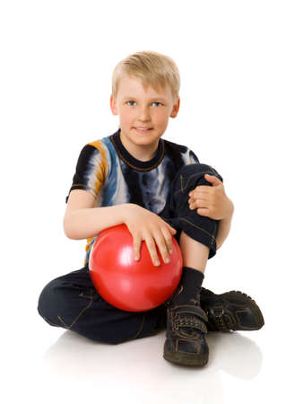 seven years Boy holding ball standing isolated on whiteの写真素材