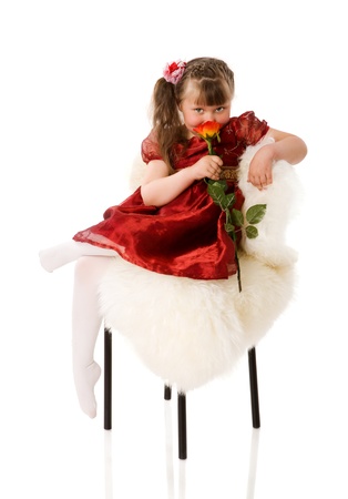 Dreaming little girl sitting isolated on whiteの写真素材