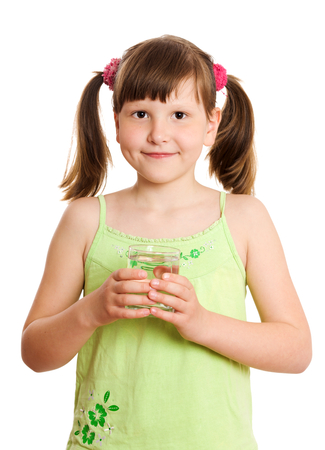 Smiling Girl holding glass of still water isolated on whiteの写真素材