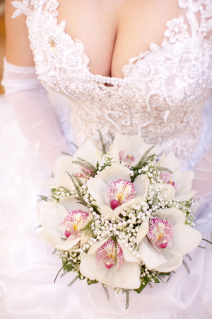 Bride holding lily orchid bouquet in handsの写真素材