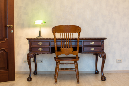 classic wooden desk chair and lamp in room interiorの写真素材