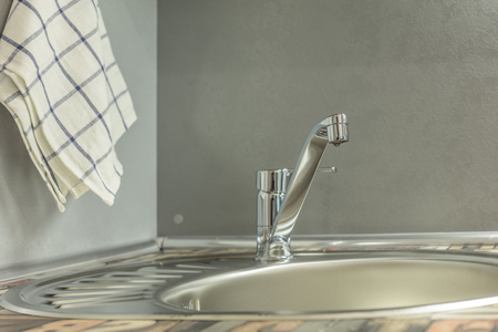 Close up of modern faucet and ceramic sink in kitchenの写真素材