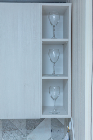 Transparent clean glasses on shelve in open cabinetの写真素材