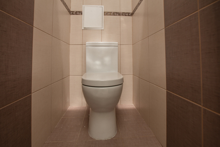 Toilet bowl in the toilet room. Restroom with brown tile decorationの写真素材
