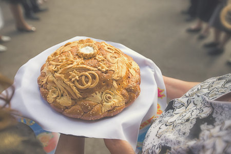 Both mothers holding Wedding round loaf and salt - welcome to new family