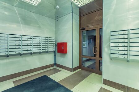Empty hall mailboxes and doors at new apartment buildingの写真素材