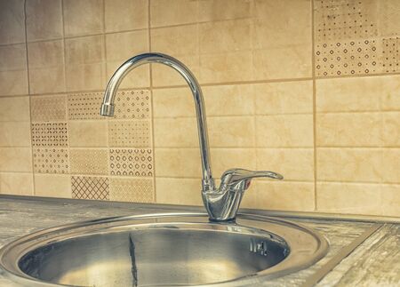 Close up of modern faucet and ceramic sink in kitchenの写真素材