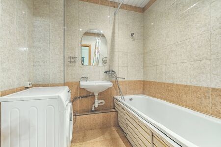 Bright clean Small white tile bathroom with bath tube and sinkの写真素材
