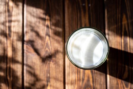 milk glass on wooden table. Healthy eating glass on wooden table, dark background. Healthy eating conceptの写真素材