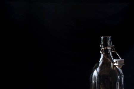 Bottle neck with old-fashioned top, close up, on black background, dark graphic designの写真素材