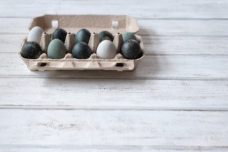 tray of eggs painted for easter. white wooden table