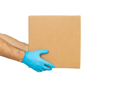 Delivery man holding cardboard boxes / copy space. Delivery by courier in rubber gloves. The...