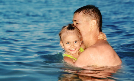 Color photo of father and daughter swimming in the seaの写真素材
