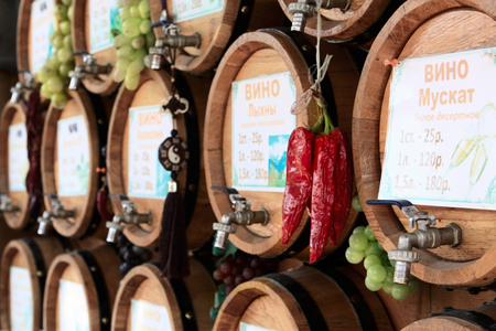 Wooden wine barrels, grapes and red hot chili peppers on the marketの写真素材