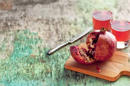 Fresh pomegranate juice and pomegranate. Pomegranate and glass of pomegranate juice on a wooden textural background.の写真素材