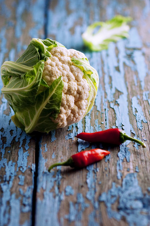 Fresh cauliflower with vegetables on a wooden table. Cabbage Bulgarian pepper chili Pumpkin Radish Healthyの写真素材