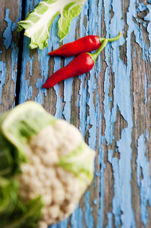 Fresh cauliflower with vegetables on a wooden table. Cabbage Bulgarian pepper chili Pumpkin Radish Healthyの写真素材