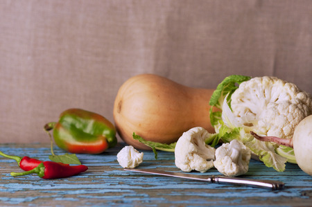 Fresh cauliflower with vegetables on a wooden table. Cabbage Bulgarian pepper chili Pumpkin Radish Healthyの写真素材
