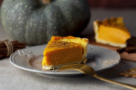 A piece of pumpkin pie with cinnamon on the table. Pie pumpkin cinnamon pastry dessertの写真素材