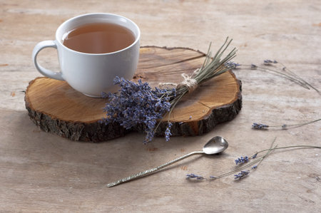 A cup of hot herbal tea and lavender on an old wooden background. Cup of tea Herbal tea Hot drink Vintage texture Backgroundの写真素材