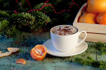 A cup of coffee on a wooden background. Coffee cappuccino with Christmas fir branches and ornaments on old wooden background. Festive decoration, postcardの写真素材