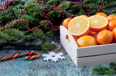 Oranges in a wooden tray with spruce branches. Christmas New Year holiday decorations Mandarin Orange Fruit Wooden background. Festive decoration, postcardの写真素材