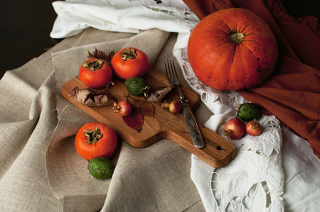 Autumn arrangement: persimmon, pumpkin, feijoa with autumn leaves. Autumn fudfoto lifestyleの写真素材